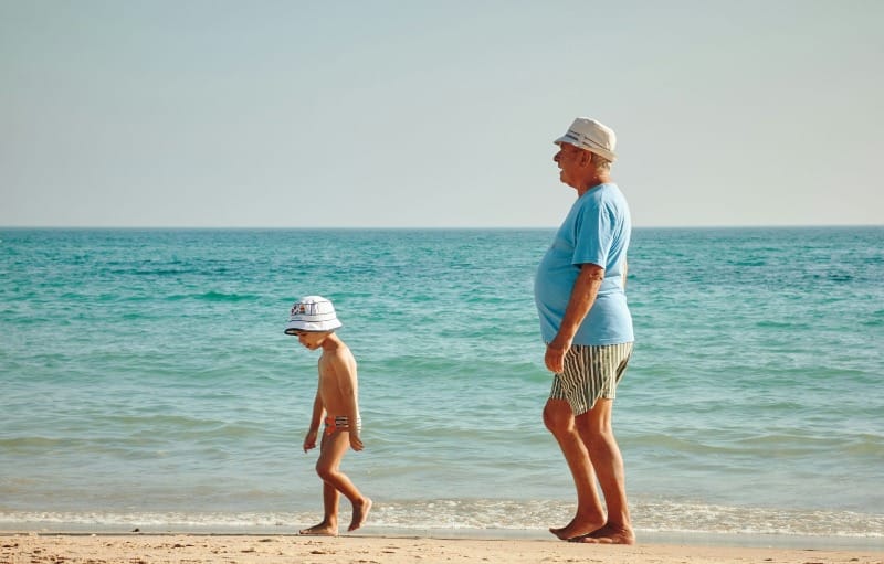 A young boy and an old man at the beach